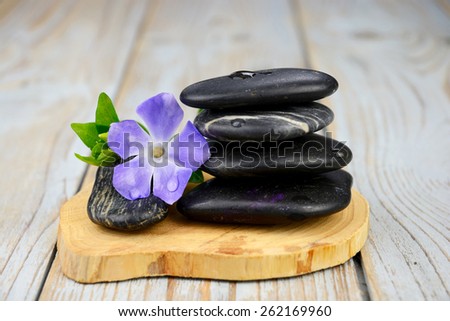 Black warmth zen stones for health piles up on old knotted wooden background with  decoration