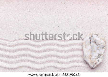 Zen garden with a white marble rock and wave pattern in the sand