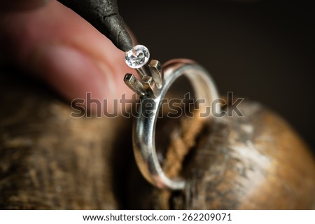 Craft jewelery making. Ring repairing. Putting the diamond on the ring. Macro shot. Royalty-Free Stock Photo #262209071