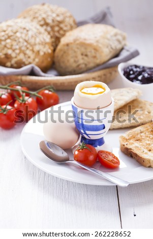 Soft-boiled egg in the morning with toast. In the background of the jam, coffee, tomatoes and snap. English breakfast, made by dSLR camera