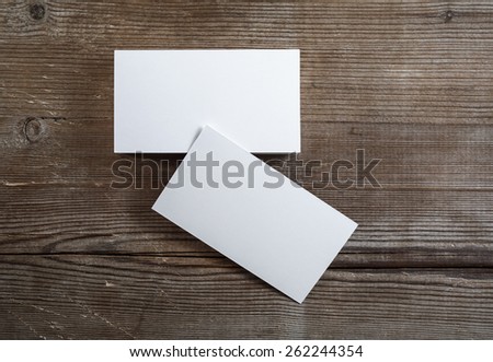 Photo of blank business cards on a dark wooden background. Mock-up for branding identity. Top view.