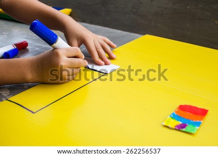 Children drawing on a yellow background.