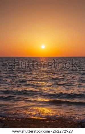 Orange sunset on the sea with the sun. Mykonos. Greece.