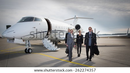 executive business team leaving corporate jet Royalty-Free Stock Photo #262274357