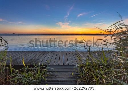 Long exposure image of a wooden walking footbridge as a concept for challenge on lake Schildmeer, Netherlands