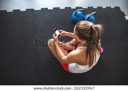 Young woman with smartphone at the gym,workout break 