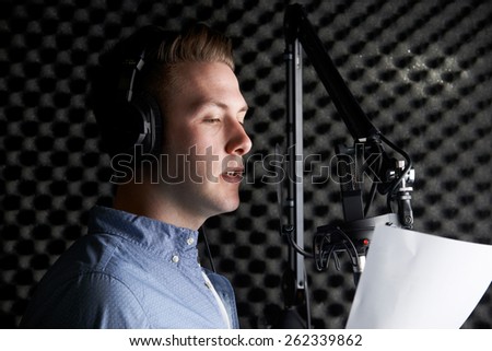 Man In Recording Studio Talking Into Microphone Royalty-Free Stock Photo #262339862