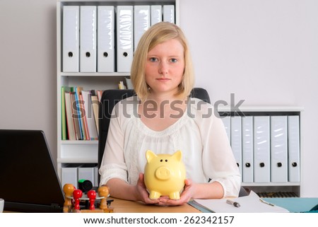 young business woman with piggy bank in the office