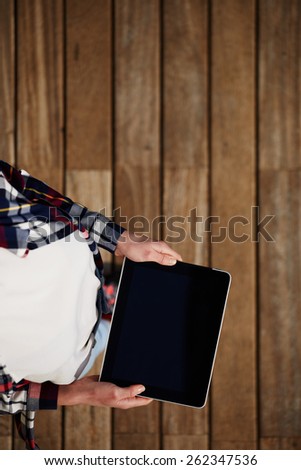 Top view shot of a woman holding digital tablet with a blank screen- closeup, fem a hands holding blank digital tablet against beautiful wooden copy space area, filtered image