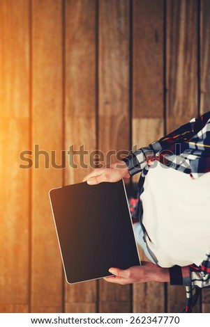 Top view shot of a woman holding digital tablet with a blank screen- closeup, fem a hands holding blank digital tablet against beautiful wooden copy space area, flare sun light, filtered image
