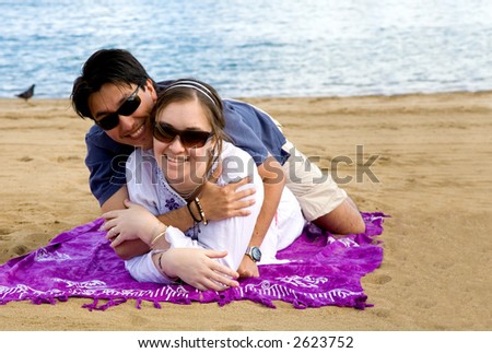 beautiful couple in love at the beach hugging each other