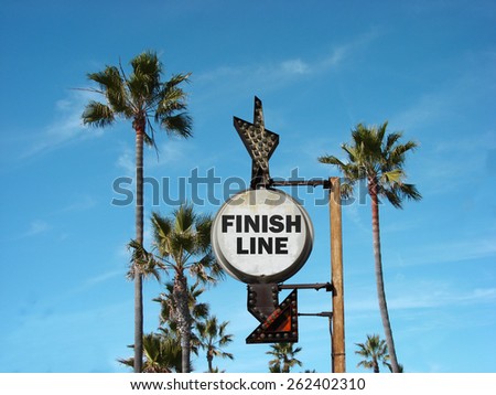  aged and worn vintage photo of finish line sign on beach                              