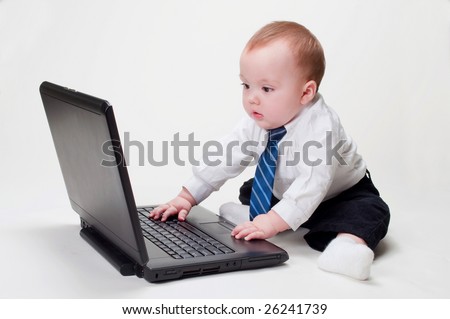 Cute baby businessman working on his laptop with a blank screen