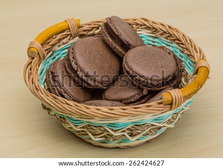 Chocolate macaroons in the bowl on the wood background