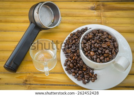 Coffee cup and coffee beans on bamboo  background