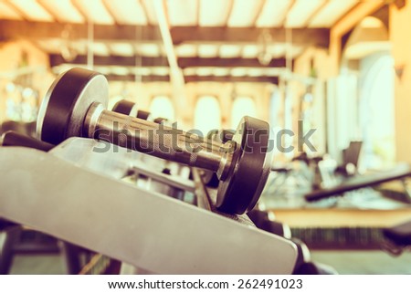 dumbbell in gym - vintage effect and sun flare filter effect