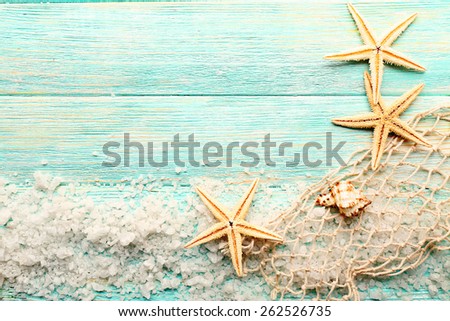 Sea stars on sea salt on wooden background