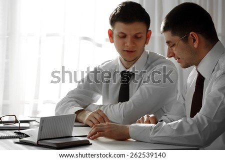 Two handsome businessmen working in office
