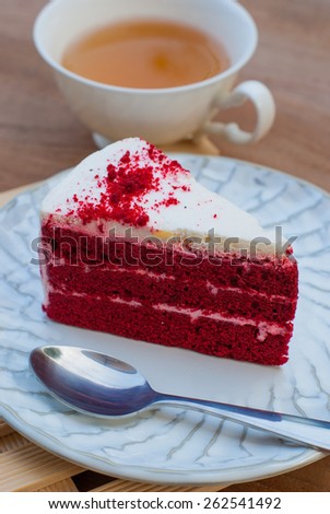 Red velvet cake closeup with cup of tea on wooden board
