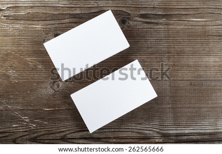 Two stacks of blank business cards on a dark wooden background. Template for branding identity. Top view.