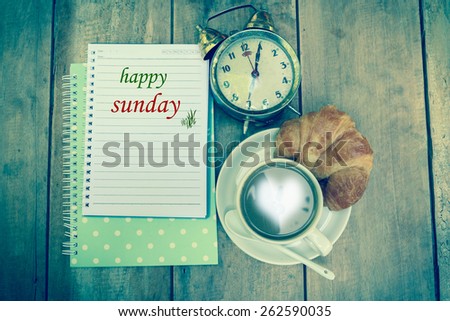    Happy sunday word and coffee cup on vintage wooden background.