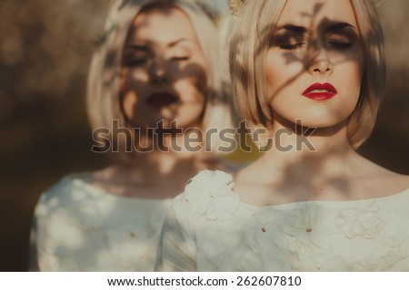 two twin sisters in a cherry orchard