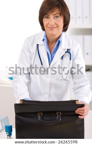 Portrait of happy senior female doctor at office, smiling.