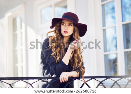 beautiful fashionable woman wearing big hat and coat Royalty-Free Stock Photo #262680716