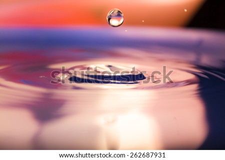 a large drop of falling water with warm colors