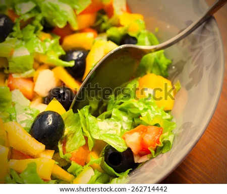 Assorted salad of green leaf lettuce with squid and black olives in bowl, close up. instahram image style