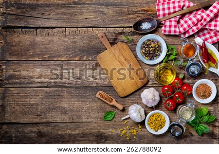 Ingredients for cooking and empty cutting board on an old wooden table. Food background  with copyspace Royalty-Free Stock Photo #262788092