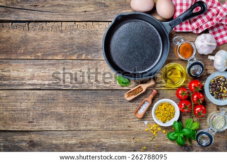  Ingredients for cooking and cast iron skillet on an old wooden table. Food background concept with copyspace Royalty-Free Stock Photo #262788095