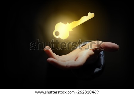 Close up of human hand holding golden key