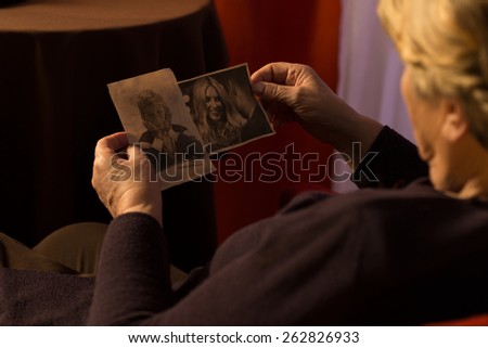 Grandma sitting in armchair and looking at grandchild's photos