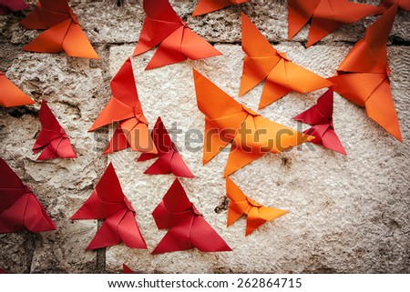 Group of birds Origami orange and red on a wall. Royalty-Free Stock Photo #262864715