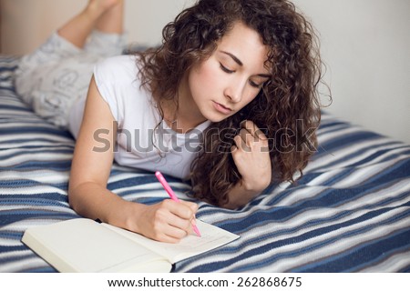 Beautiful teenage girl in underwear writing notes in diary Royalty-Free Stock Photo #262868675