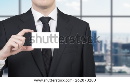 Businessman in office with a blank business card
