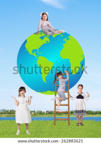Little smiling girl with a globe in a summer field