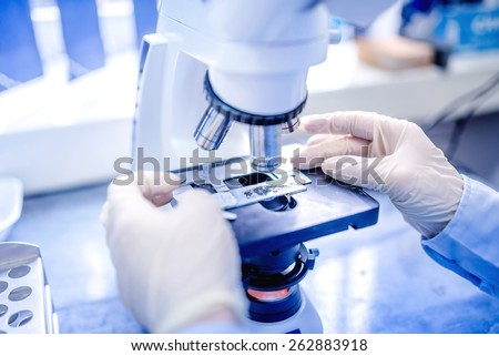 scientist hands with microscope, examining samples and liquid. Medical research with technical equipment Royalty-Free Stock Photo #262883918