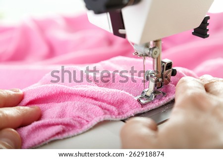 Working on sewing machine. Close look of hands and needle