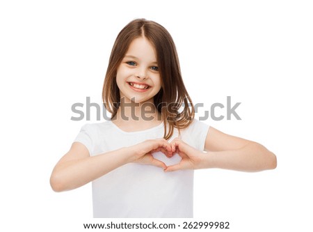 friendship, t-shirt design and happy people concept - smiling little girl in white blank t-shirts showing heart with hands Royalty-Free Stock Photo #262999982