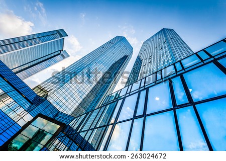 Bottom view of modern skyscrapers in business district against blue sky Royalty-Free Stock Photo #263024672