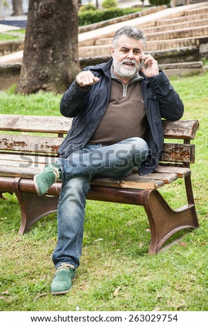 Attractive bearded man talking on phone on the street