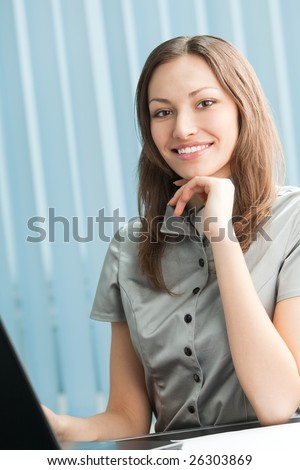 Happy businesswoman working with laptop at office