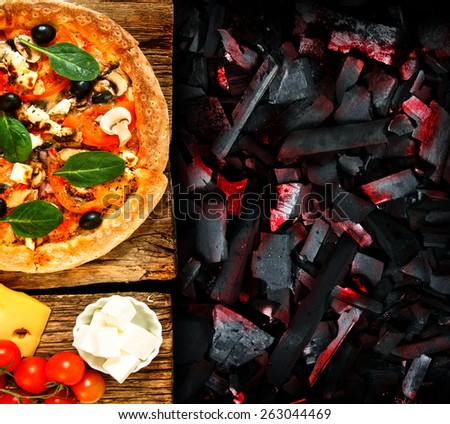 Pizza on a wooden board and components for a pizza. Concept a pizza prepared on coals.