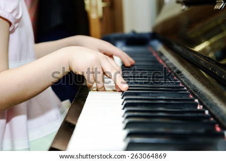 Girl's hands and piano keyboard close-up view, education concept Royalty-Free Stock Photo #263064869