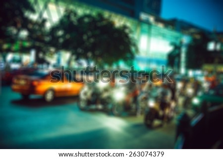 people in bokeh, street of night Bangkok, motorcyclists on city road