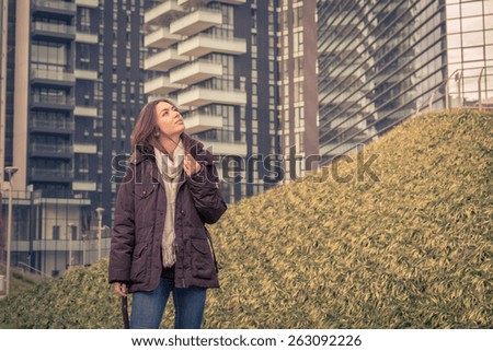 Young beautiful girl with long hair posing in the city streets