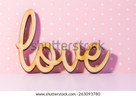 Wooden Love inscription on pink background.