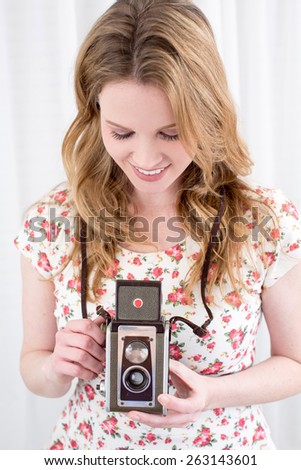 Young woman using her antique camera
